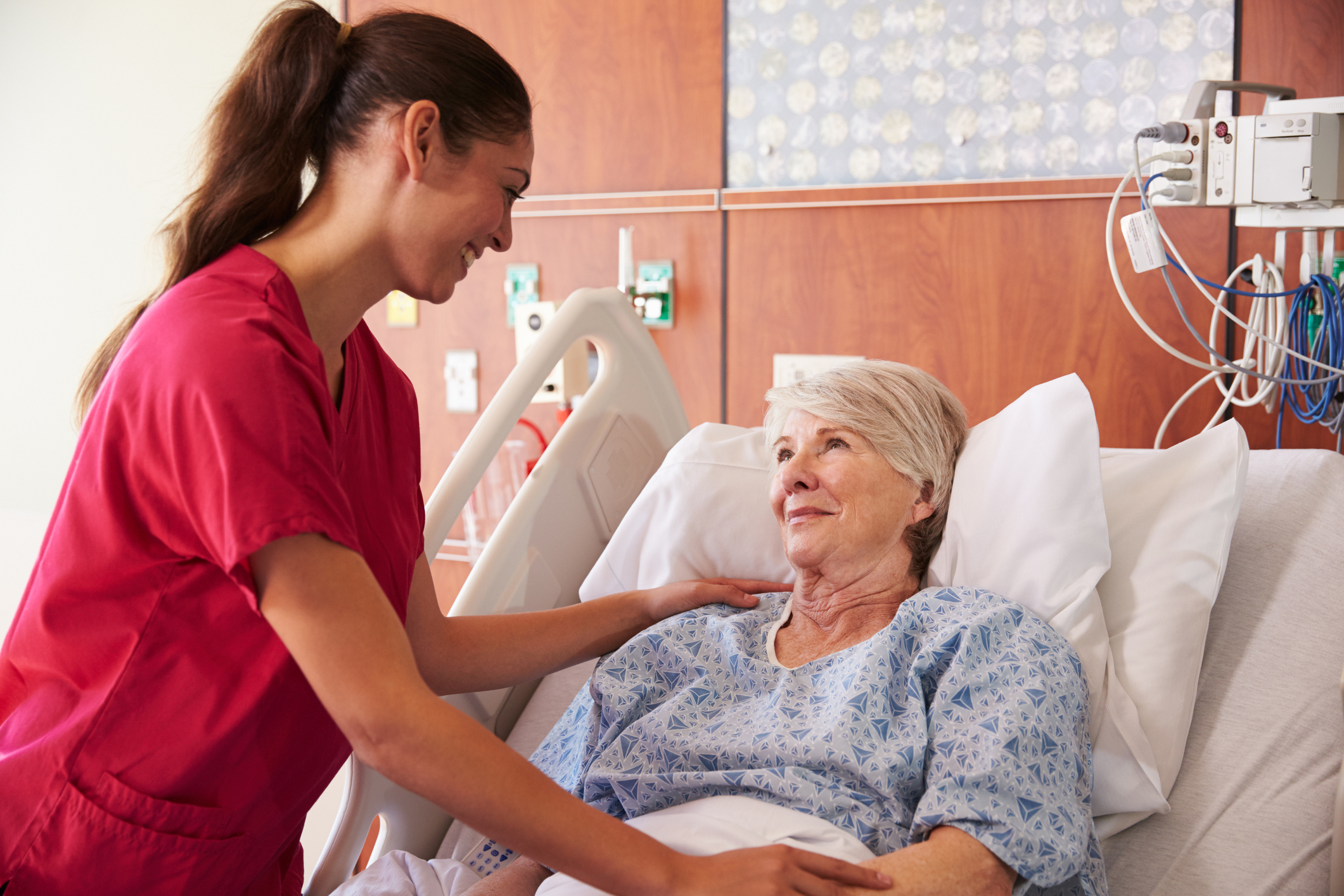 Nurse Talking To Senior Female Patient In Hospital Bed